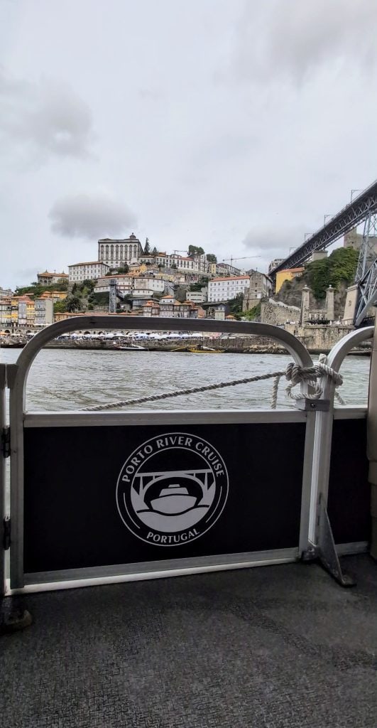 Enjoy a Porto river cruise on the Douro River, taking in stunning views of city buildings and the iconic Dom Luís I Bridge in the background.